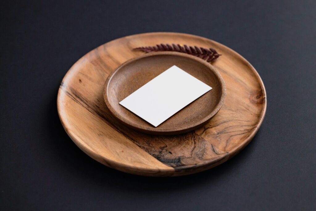 Home A minimalist setup featuring a wooden plate and blank card for branding or presentations.